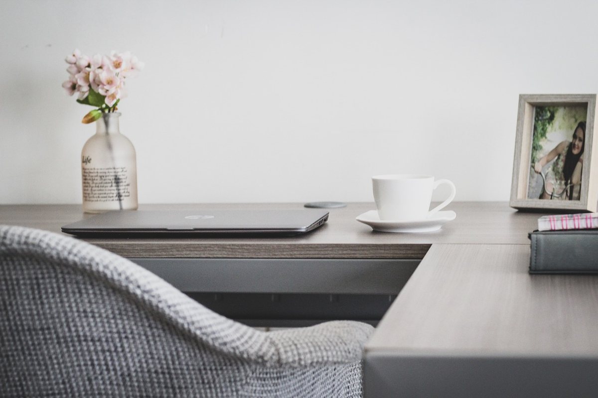 A desk and upholstered chair with clear floor space behind them.